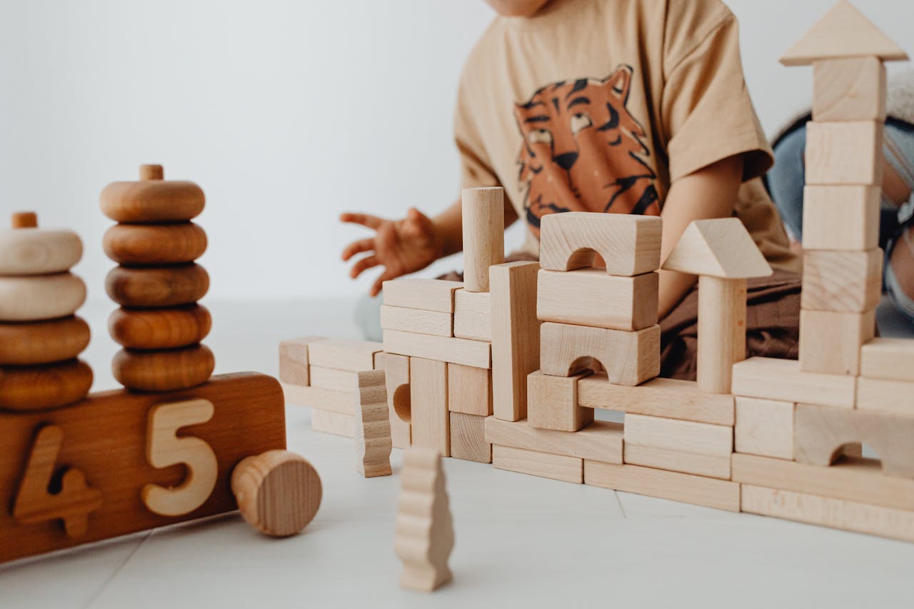 Mastering the First Impression: Your intriguing post title goes here A child is building structures with wooden blocks in a playroom, focusing on creativity and learning.